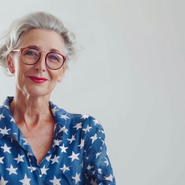Mulher idosa de óculos e camisa estampada de estrelas